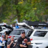 Attendee catches football in parking lot during Family Day tailgate.